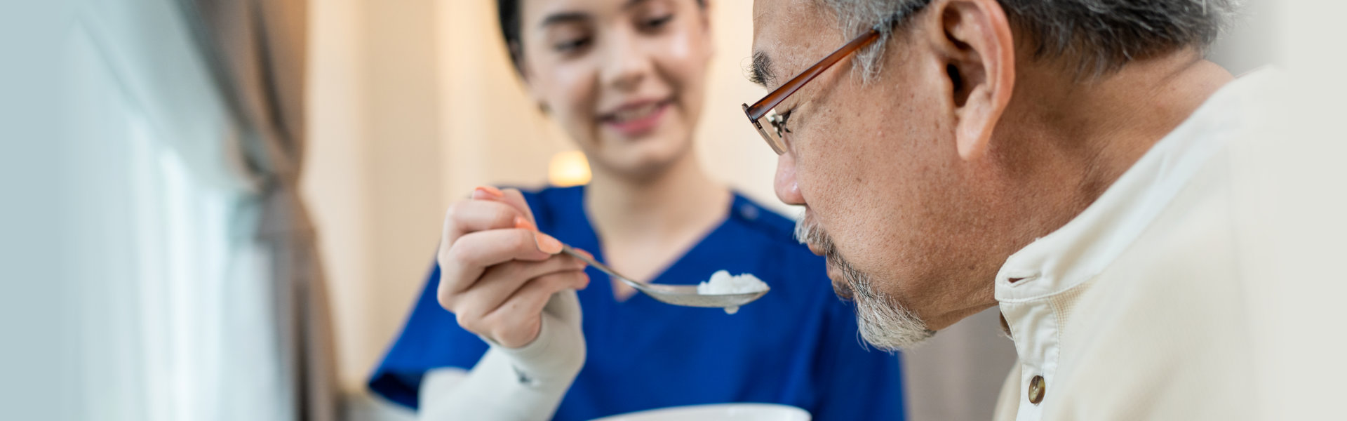 caregiver woman feeding a senior man