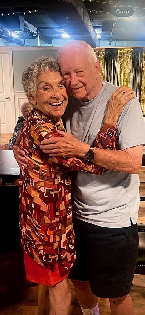Two people smiling and hugging closely.