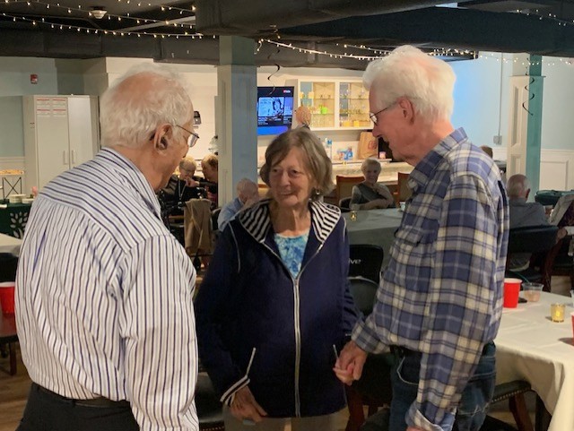 three elderly people talking