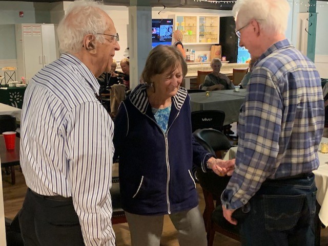 three elderly people talking